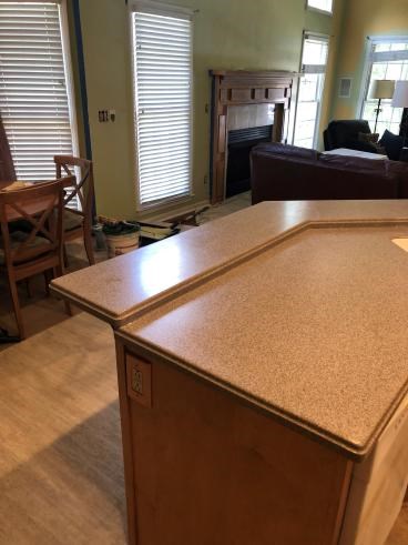Kitchen counter with nearby living room in home renovation.