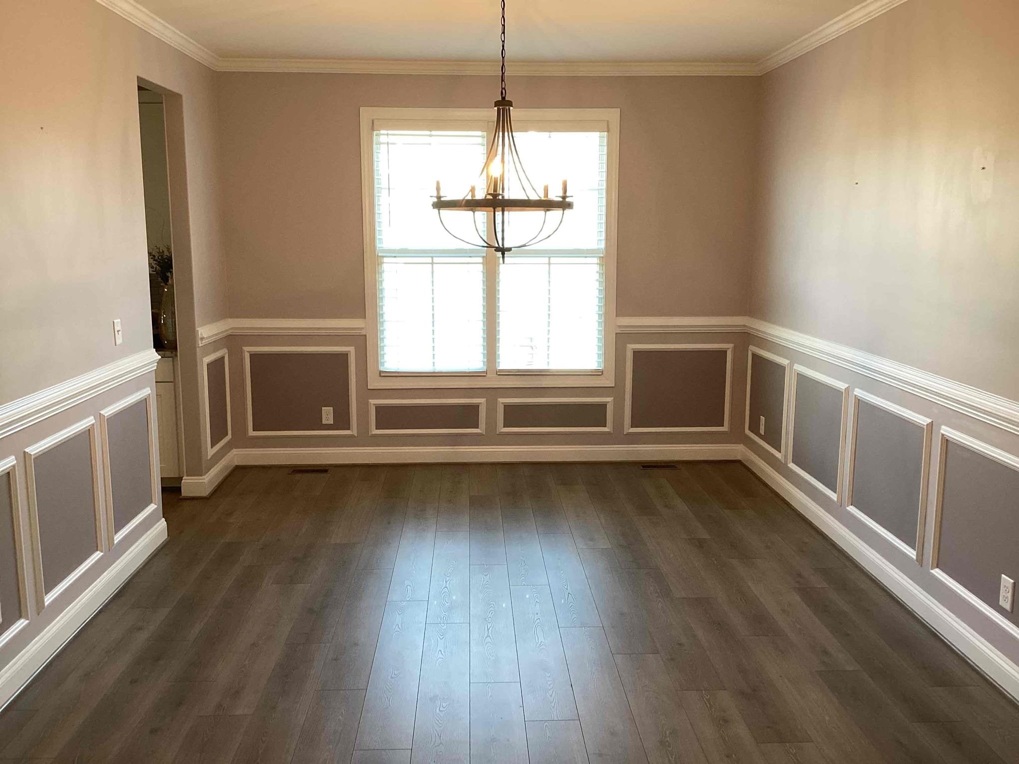 Empty dining room with wood floor and chandelier.