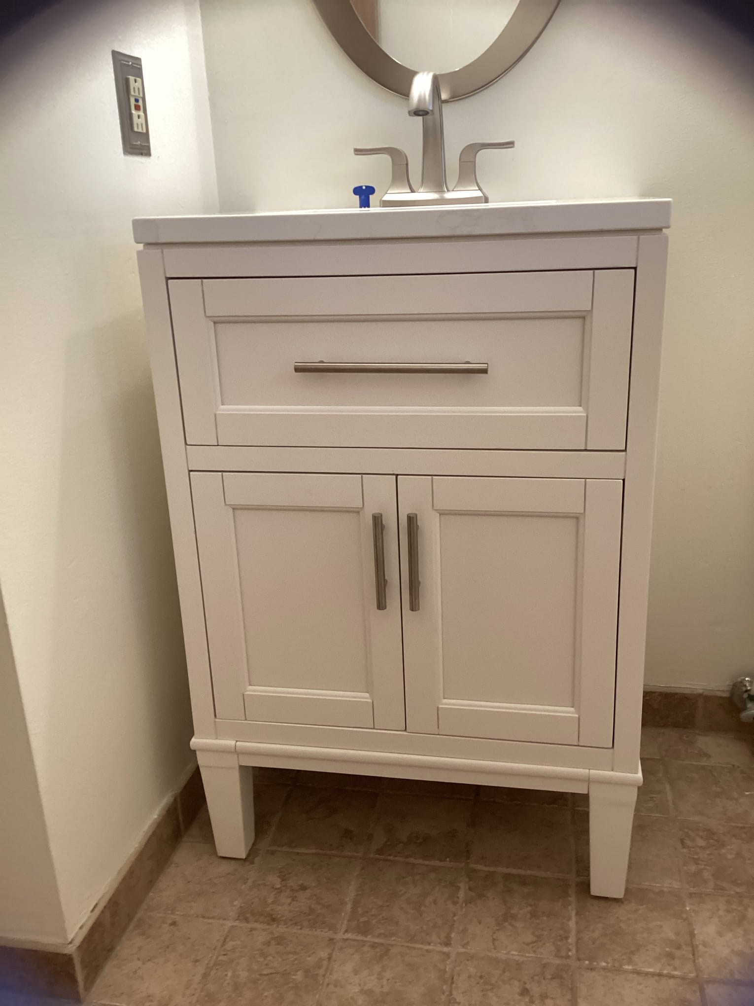 White bathroom vanity with silver faucet and handles.